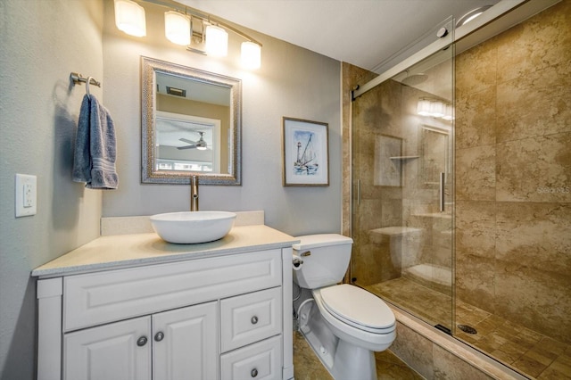 bathroom featuring vanity, toilet, ceiling fan, and a shower with shower door