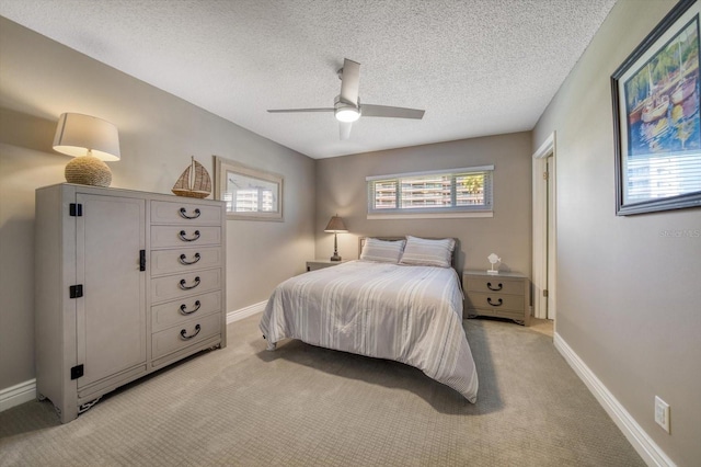 carpeted bedroom featuring ceiling fan and a textured ceiling