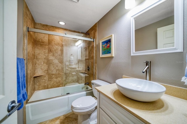 full bathroom featuring combined bath / shower with glass door, tile patterned floors, vanity, and toilet