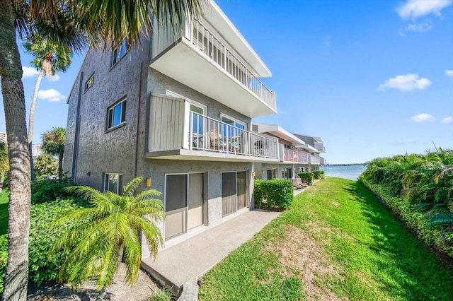 rear view of house featuring a yard and a water view