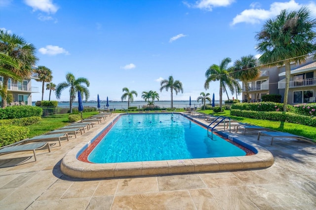 view of swimming pool with a patio area and a water view