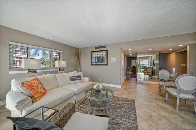 living room with a textured ceiling and a wealth of natural light