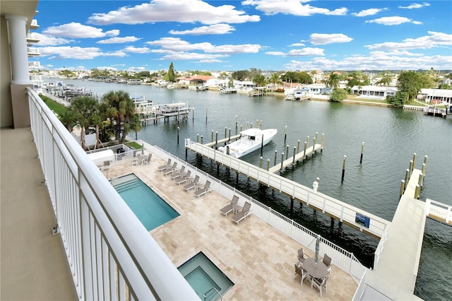 view of dock featuring a patio area, a water view, and a community pool