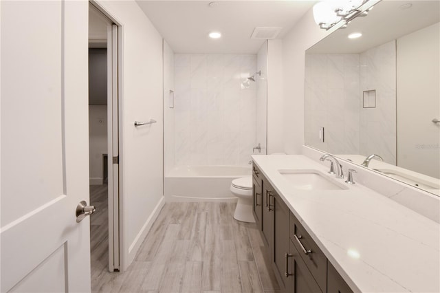 full bathroom with vanity, toilet, wood-type flooring, and tiled shower / bath combo