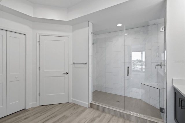 bathroom featuring hardwood / wood-style floors, vanity, and a shower with door