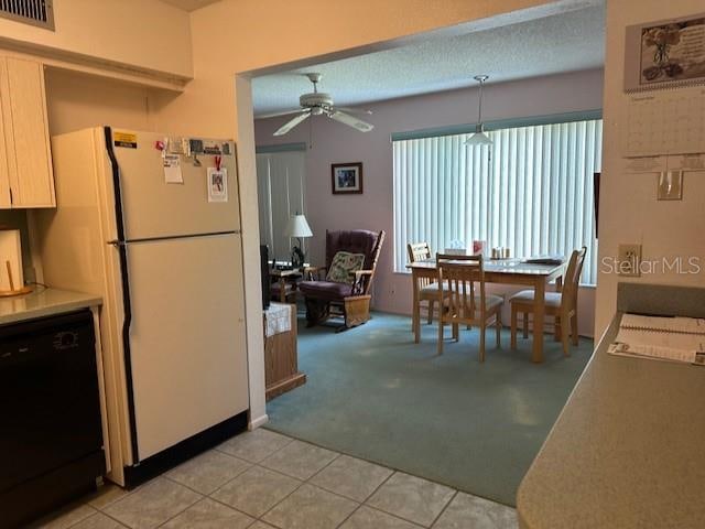 dining room with ceiling fan and light colored carpet