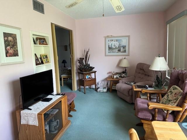 interior space with carpet flooring, ceiling fan, and a textured ceiling