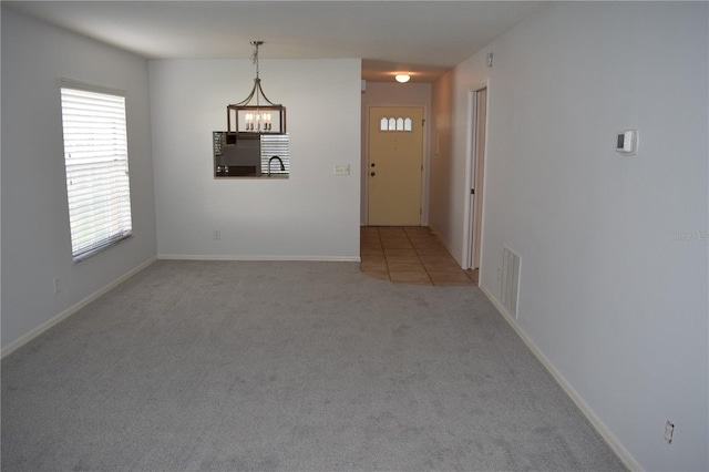 interior space with light carpet, a notable chandelier, and sink