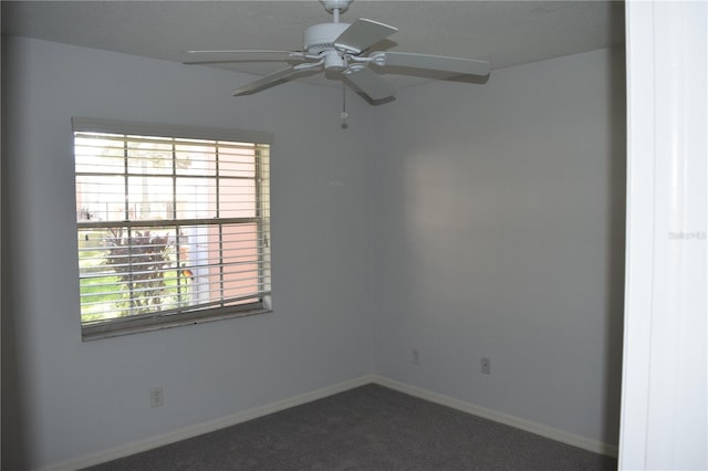 carpeted empty room with ceiling fan and a wealth of natural light