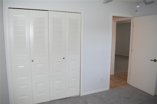 unfurnished bedroom with carpet, ceiling fan, and a closet