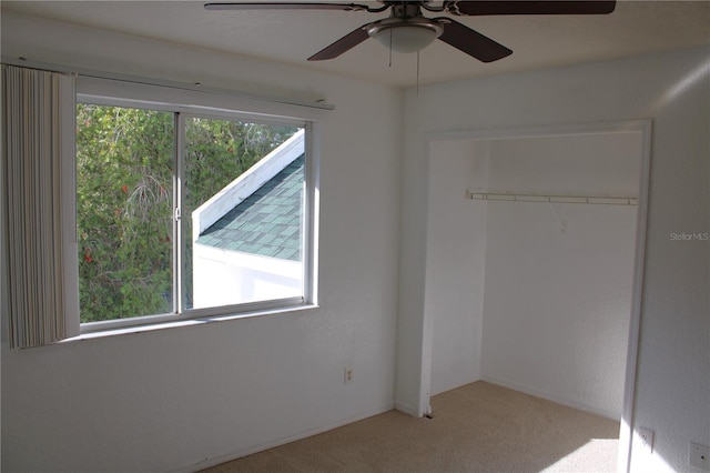 unfurnished bedroom featuring ceiling fan, a closet, and light colored carpet