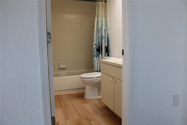 full bathroom with shower / bathtub combination with curtain, hardwood / wood-style floors, vanity, and toilet