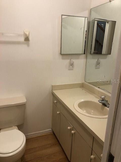 bathroom featuring hardwood / wood-style floors, vanity, and toilet