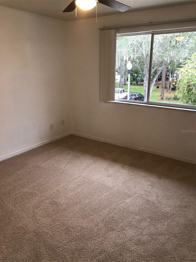 carpeted spare room with ceiling fan