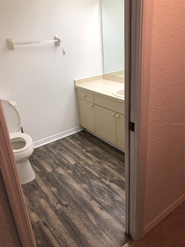 bathroom featuring hardwood / wood-style flooring, vanity, and toilet