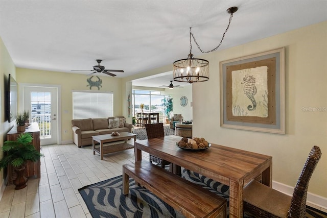 dining room with ceiling fan with notable chandelier and light hardwood / wood-style floors