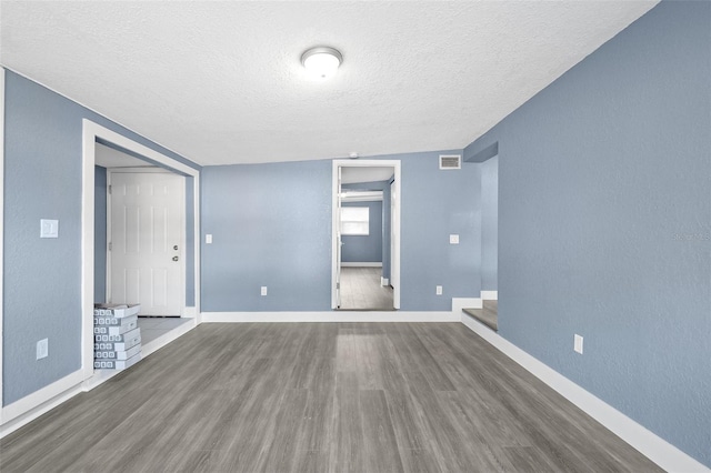 unfurnished room featuring a textured ceiling and hardwood / wood-style flooring