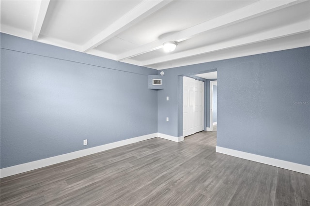 unfurnished room featuring dark hardwood / wood-style flooring and beamed ceiling