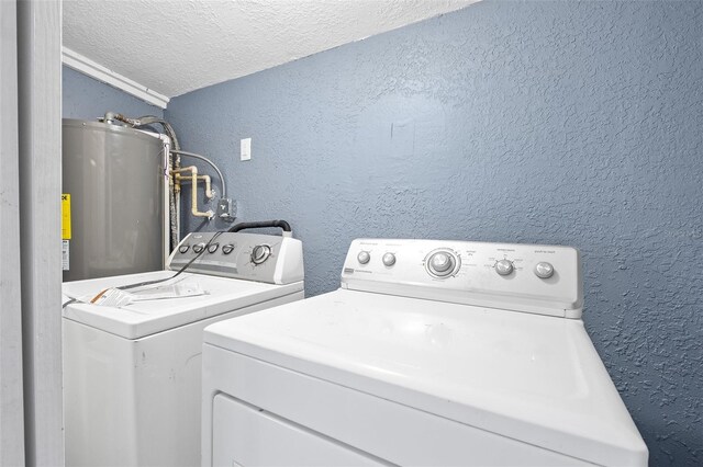 laundry room with washer and dryer, a textured ceiling, and water heater