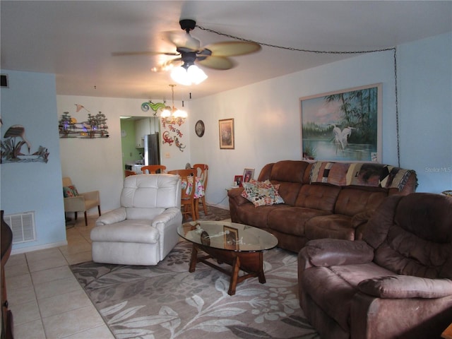 living room featuring light tile patterned floors and ceiling fan with notable chandelier