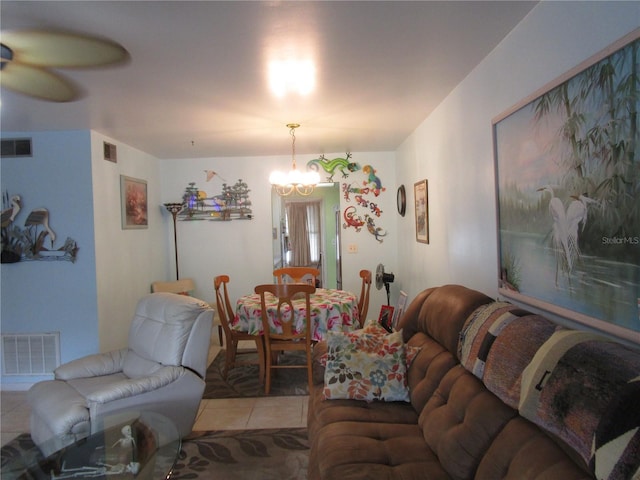 living room featuring tile patterned flooring and ceiling fan with notable chandelier