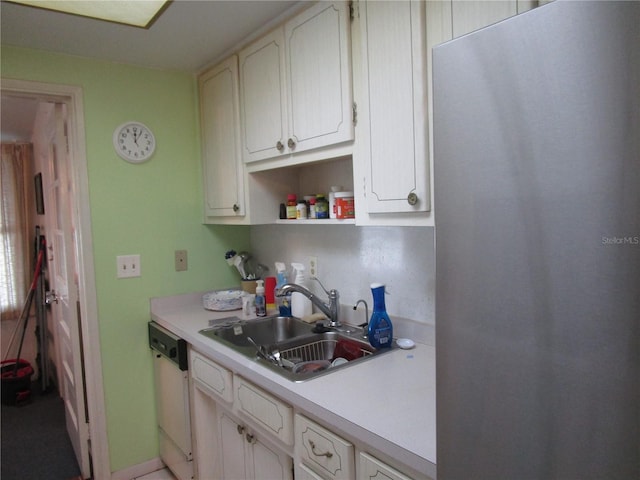 kitchen with white cabinets, dishwasher, stainless steel fridge, and sink