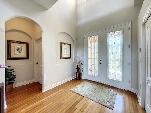 foyer with light wood-type flooring, french doors, and a healthy amount of sunlight