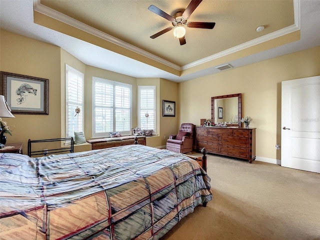 bedroom featuring visible vents, light colored carpet, a tray ceiling, and ornamental molding