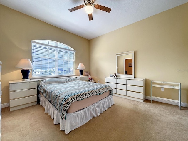 bedroom featuring a ceiling fan, light colored carpet, and baseboards