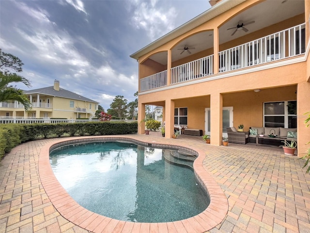 view of pool with an outdoor living space, a fenced in pool, fence, a patio area, and a ceiling fan