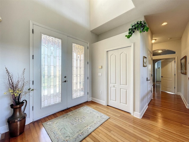 foyer with wood finished floors, french doors, and baseboards