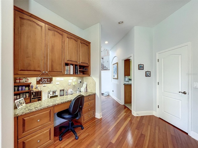 office with built in desk, recessed lighting, baseboards, and wood finished floors