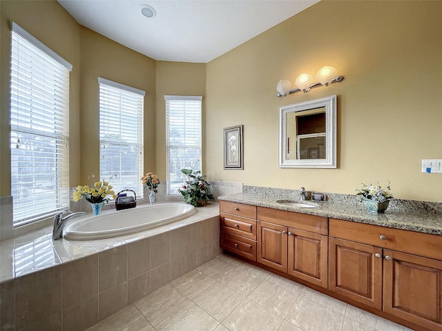 bathroom featuring tile patterned floors, vanity, and a garden tub