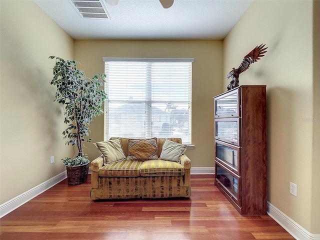 sitting room featuring visible vents, baseboards, and wood finished floors