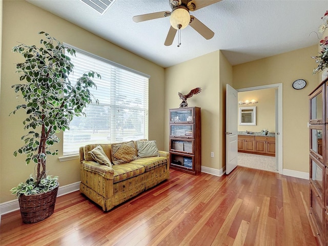 sitting room featuring light wood finished floors, visible vents, and baseboards