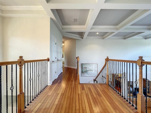 hallway featuring visible vents, an upstairs landing, beam ceiling, coffered ceiling, and wood-type flooring