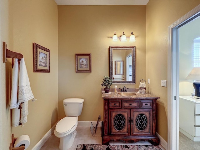 bathroom with tile patterned flooring, toilet, vanity, and baseboards