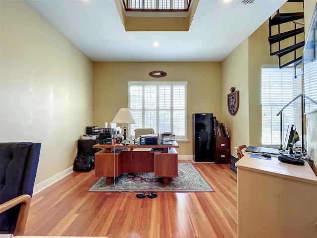 office featuring a wealth of natural light, light wood-type flooring, and baseboards