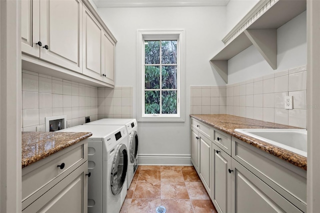 laundry area featuring a sink, baseboards, washer and dryer, cabinet space, and crown molding