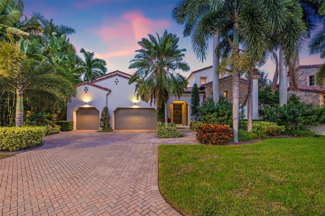 mediterranean / spanish-style house featuring a yard and a garage