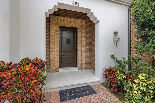 property entrance featuring brick siding and stucco siding