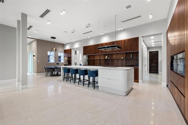 kitchen with a large island, modern cabinets, open shelves, and light countertops