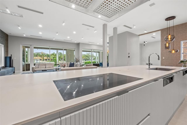 kitchen featuring a sink, visible vents, open floor plan, hanging light fixtures, and light countertops