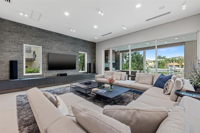 living room featuring an accent wall, recessed lighting, and visible vents