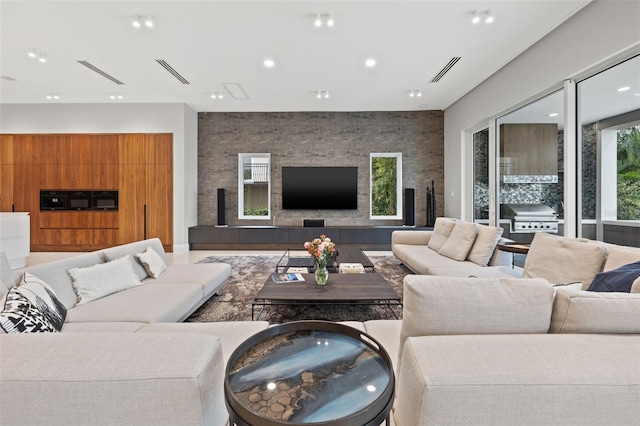 living room featuring an accent wall, visible vents, and recessed lighting