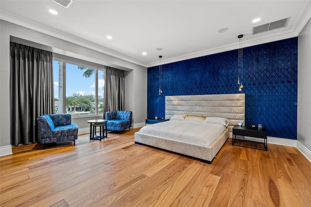 bedroom with light wood finished floors, baseboards, visible vents, and ornamental molding