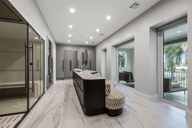 kitchen featuring a kitchen island with sink, recessed lighting, built in refrigerator, visible vents, and modern cabinets