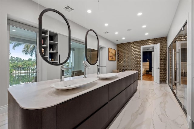 bathroom featuring double vanity, marble finish floor, visible vents, and a sink