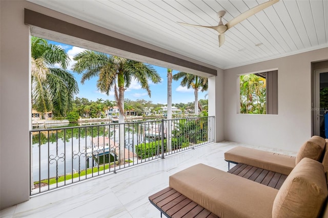 sunroom featuring a ceiling fan, wooden ceiling, and a water view