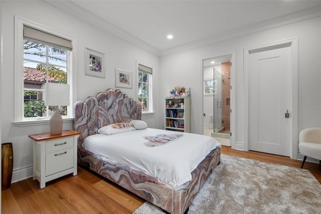 bedroom featuring light wood-style floors, recessed lighting, ornamental molding, and ensuite bathroom